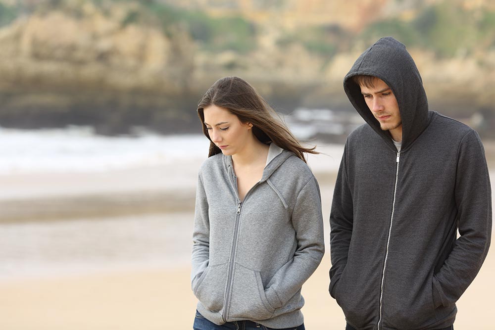 anaheimlighthouse-how-do-i-live-with-a-recovering-addict-article-photo-couple-of-angry-and-sad-teenagers-together-walking-on-the-beach-370490444