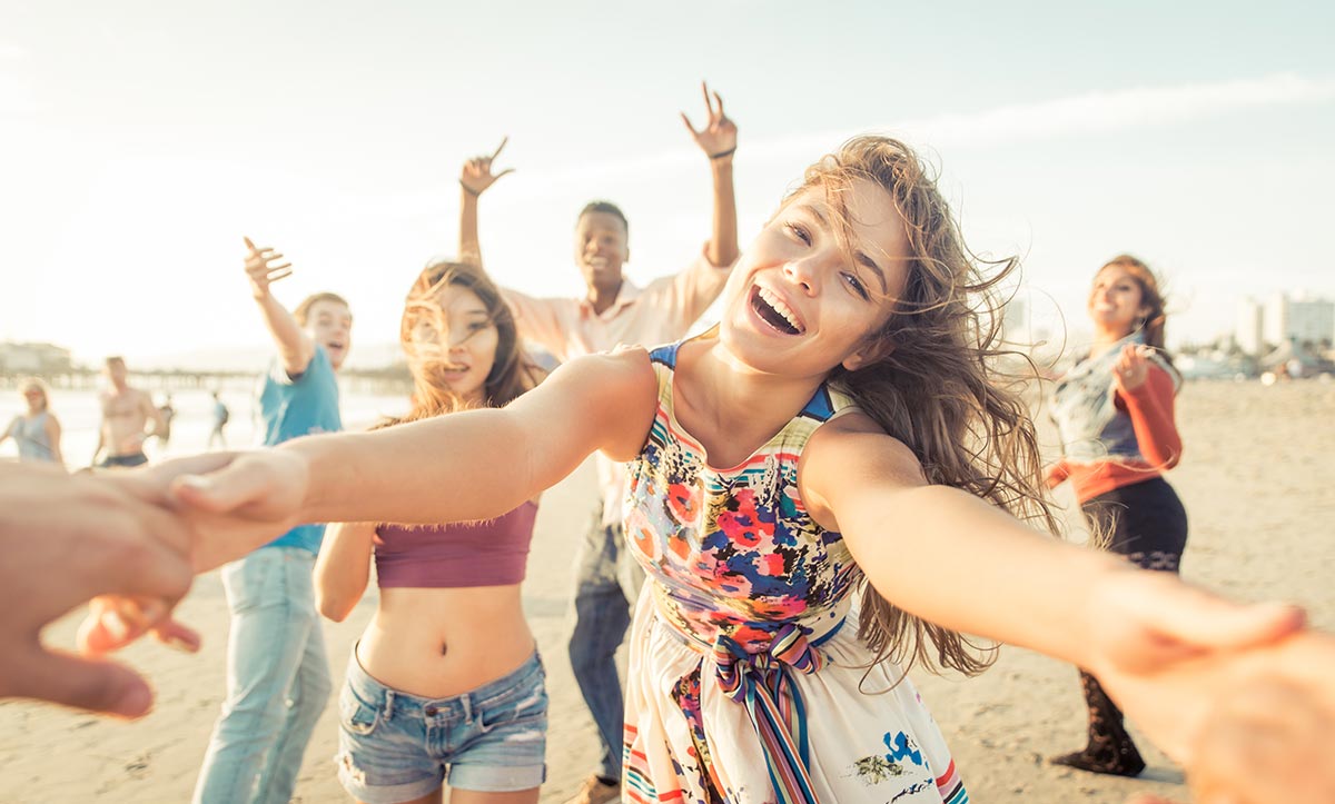 anaheimlighthouse-summertime-sobriety-article-photo-group-of-friends-having-fun-and-dancing-on-the-beach-spring-break-party-on-the-beach-380872402