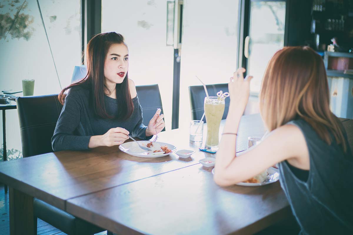 anaheimlighthouse-how-do-i-handle-my-first-sober-heartbreak-article-photo-two-young-female-friends-laugh-and-having-lunch-together-at-restaurant-726138742