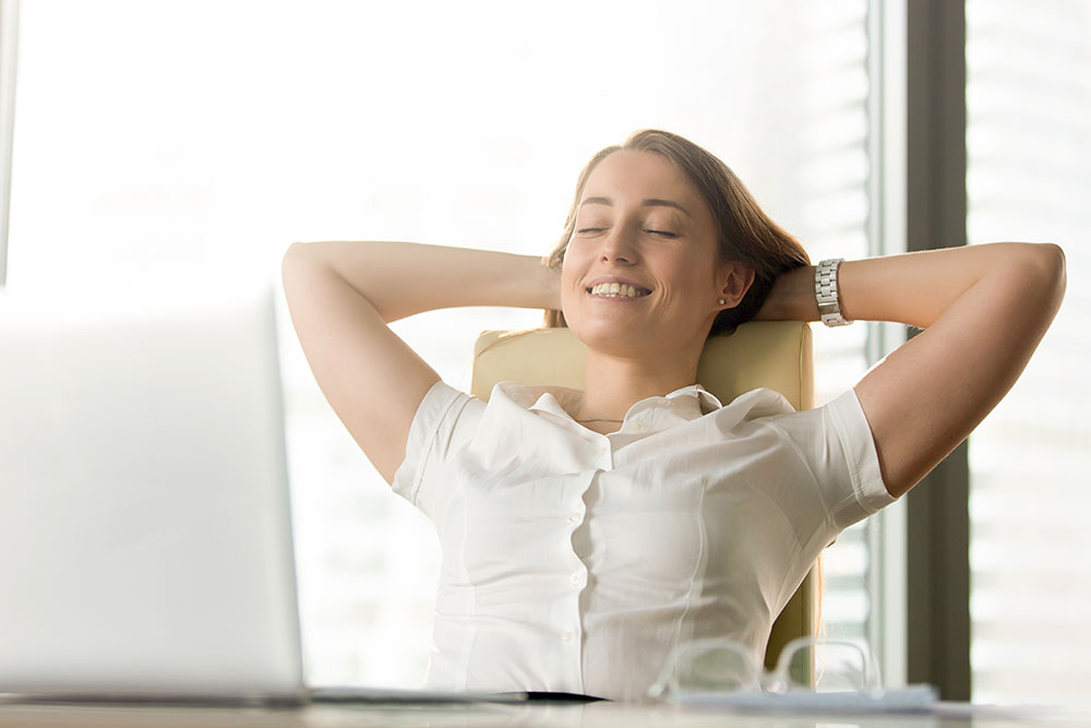 anaheimlighthouse-seven-of-the-best-recovery-mantras-article-photo-happy-smiling-woman-feels-relaxed-in-office-home-enjoying-moment-no-stress-at-work-practicing-692204329