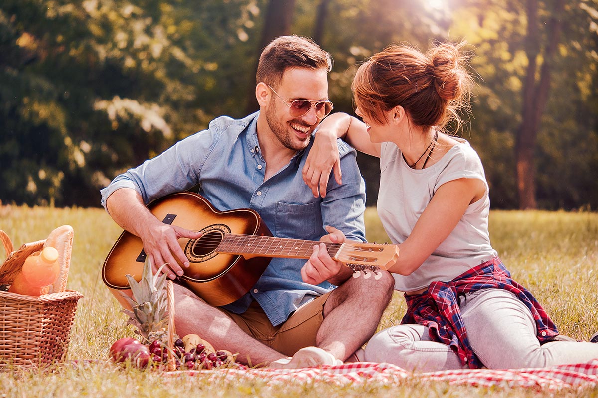 anaheimlighthouse-should-people-date-in-early-sobriety-article-photo-picnic-time-young-couple-having-fun-with-guitar-on-picnic-in-the-park-love-and-tenderness-dating-675373411
