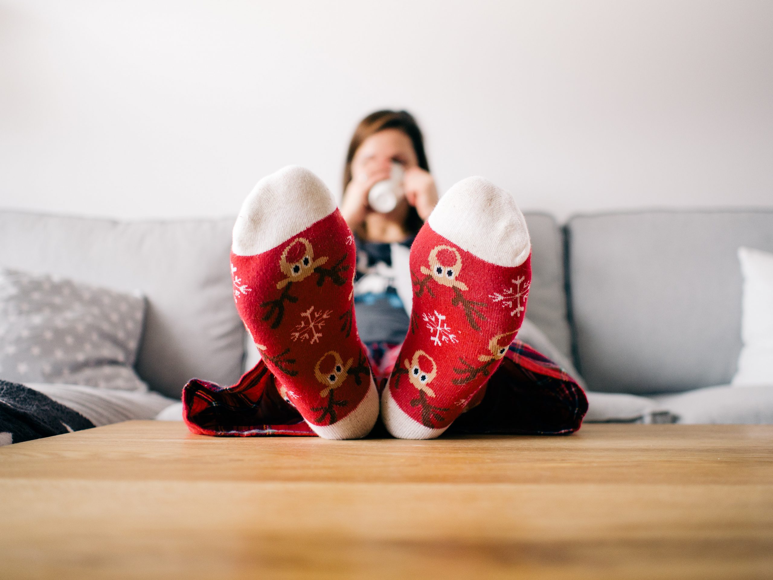 a person sits on a couch with holiday themed socks