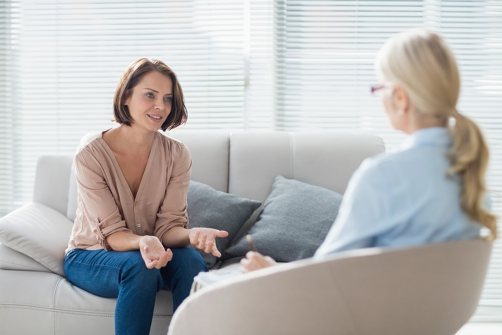 Woman talking to therapist on sofa at home
