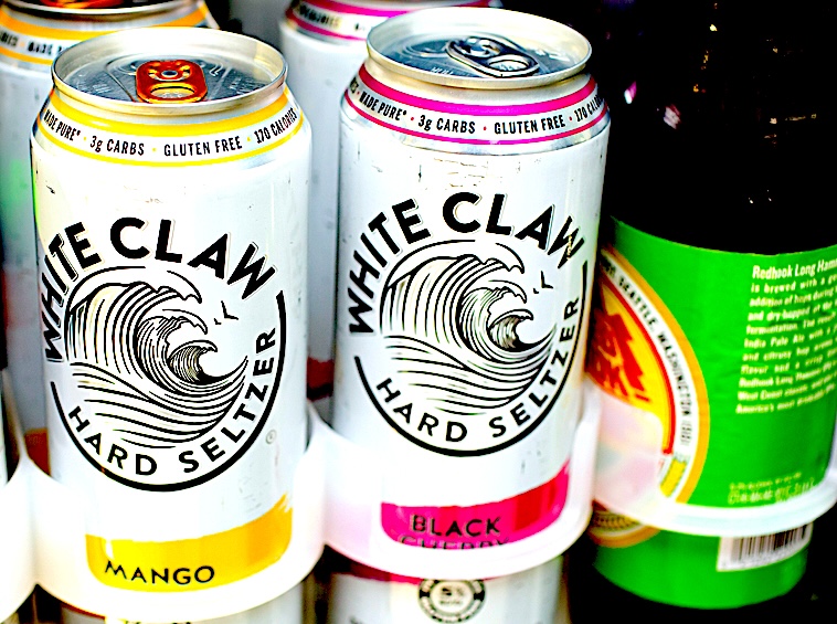 Mango and black cherry flavors White Claw tall cans on display