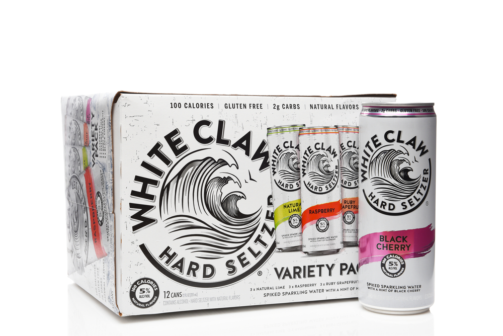 A can of White Claw behind a full box of White Claw