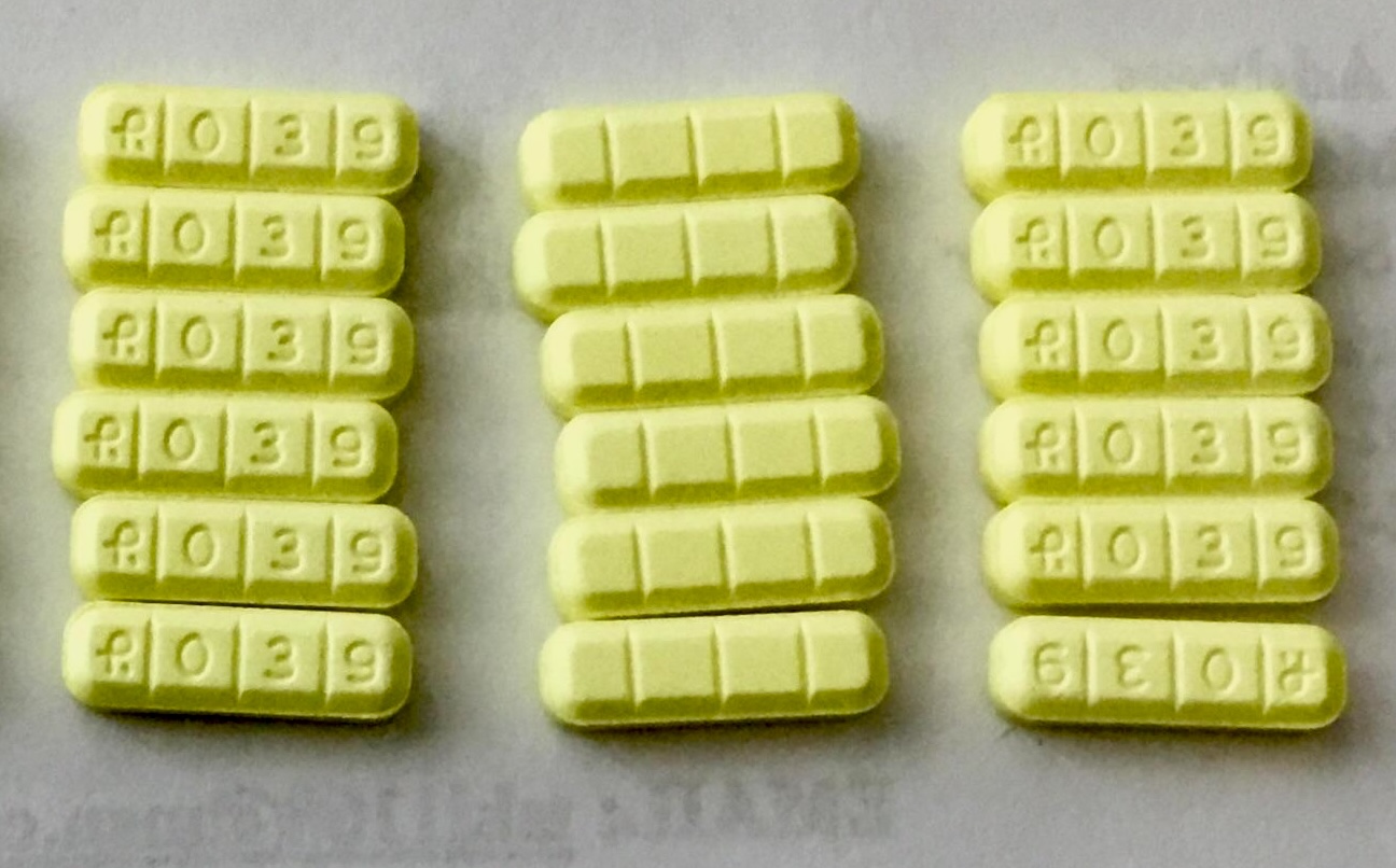Even rows of R039 pills on a white surface 