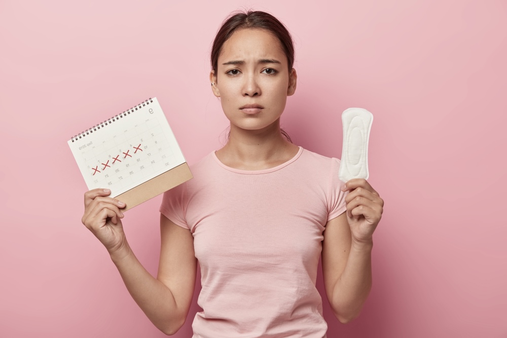 Woman holding a sanitary pad and calendar