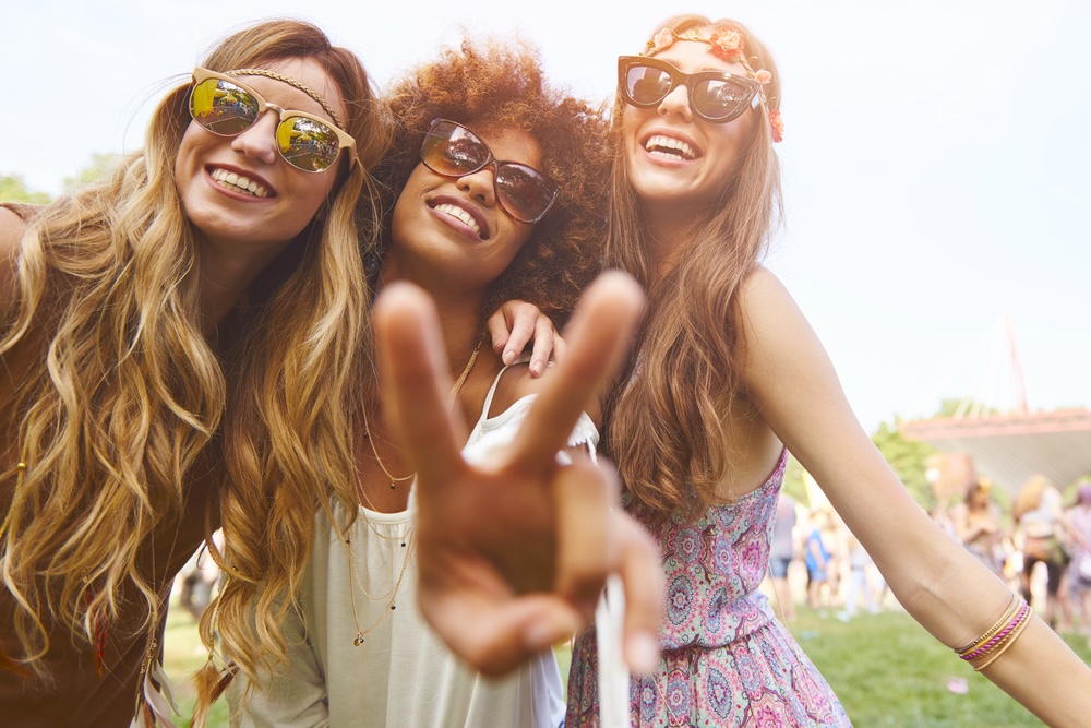 Three female friends enjoying at a music summer festival