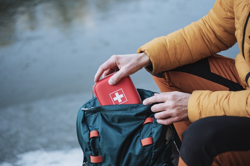 Man putting first aid kit inside his bag