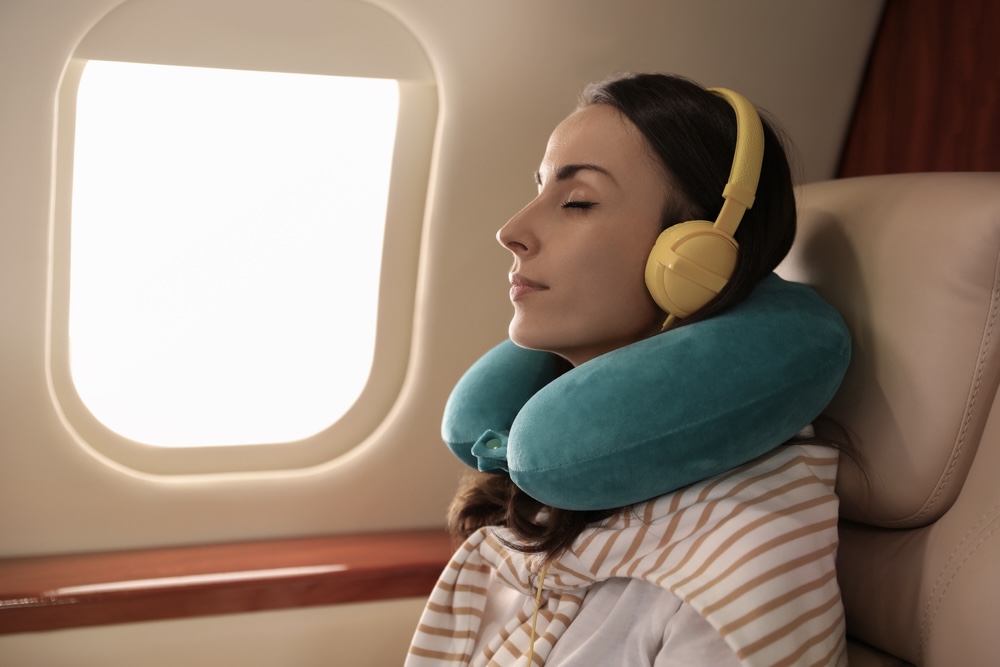 Woman sleeping inside the plane with noise canceling headphones