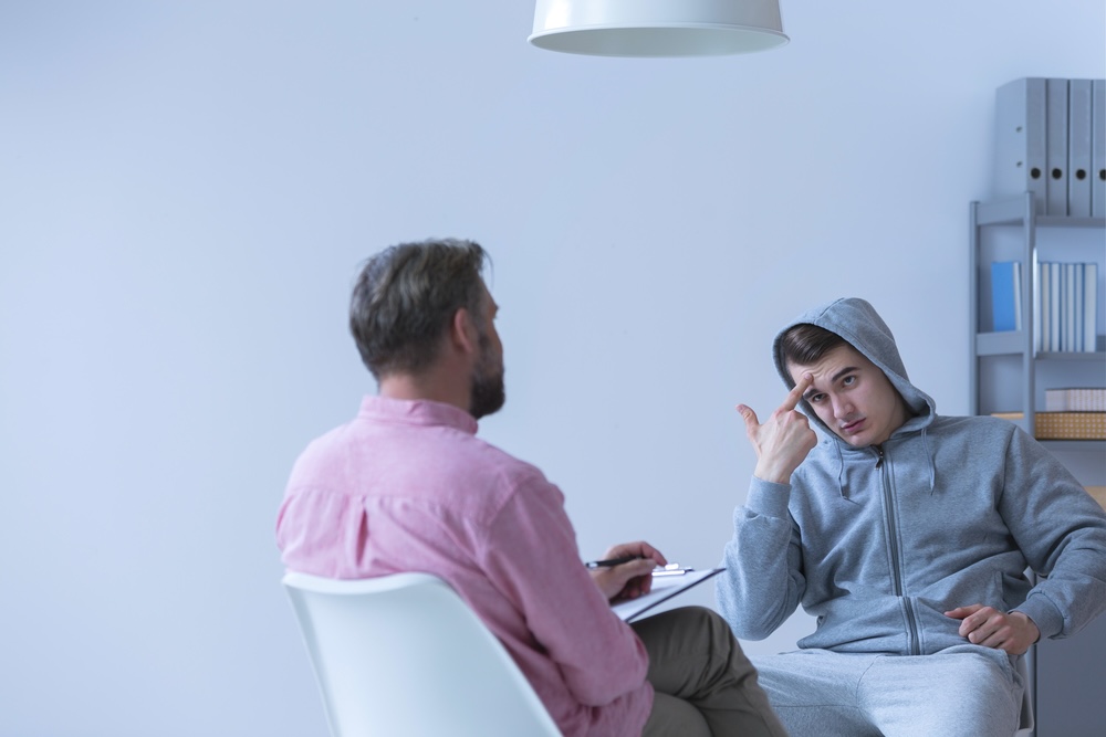 Man in a hoodie consult with rehab specialist about meth addiction