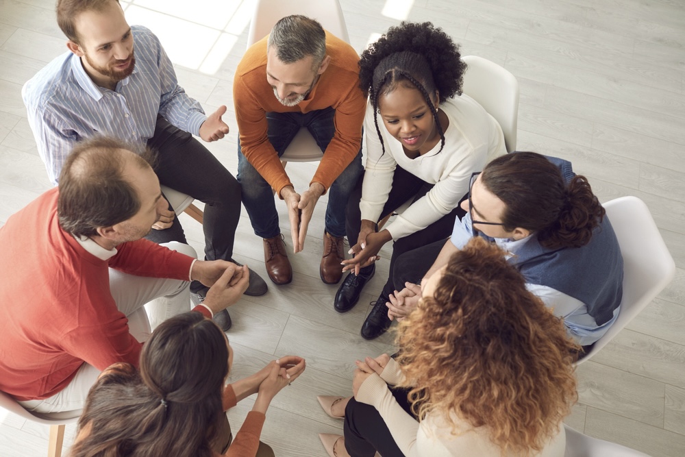 People in addiction recovery sitting in a circle for group therapy