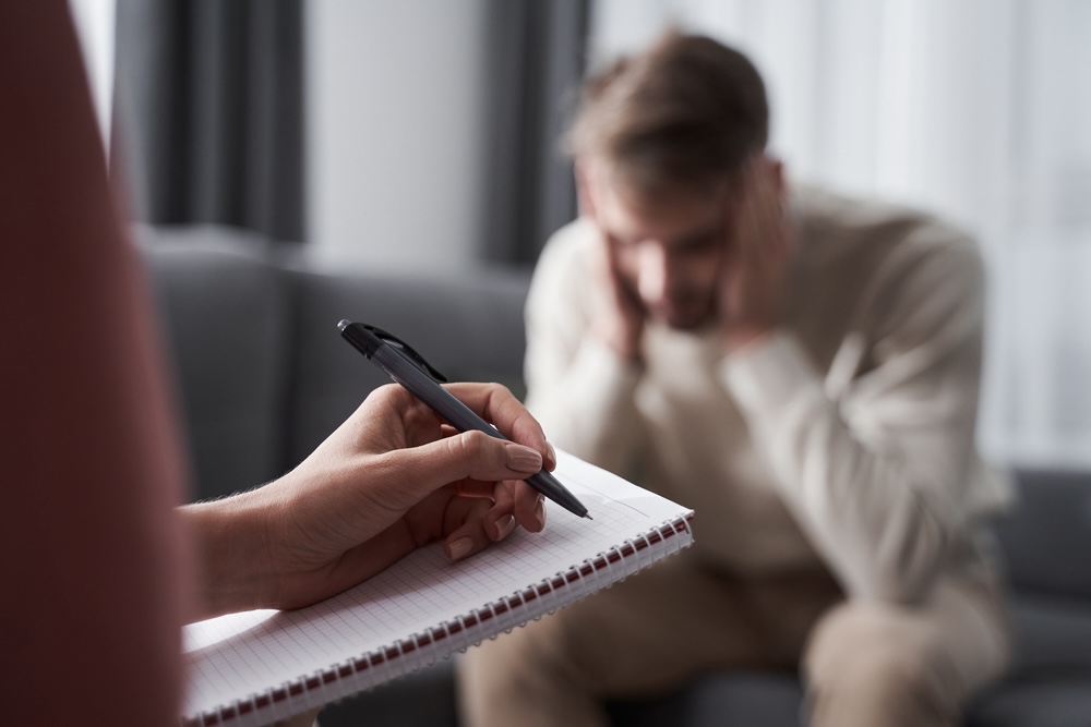 Upset male talking to a rehab addiction therapist 