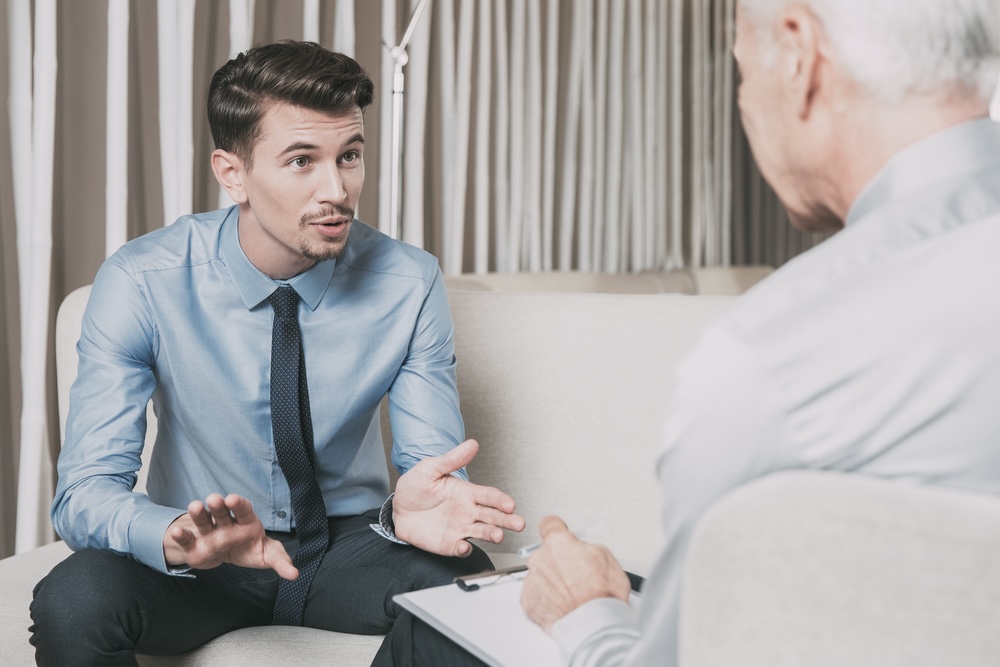 Man in a corporate attire attending therapy session after completing rehab