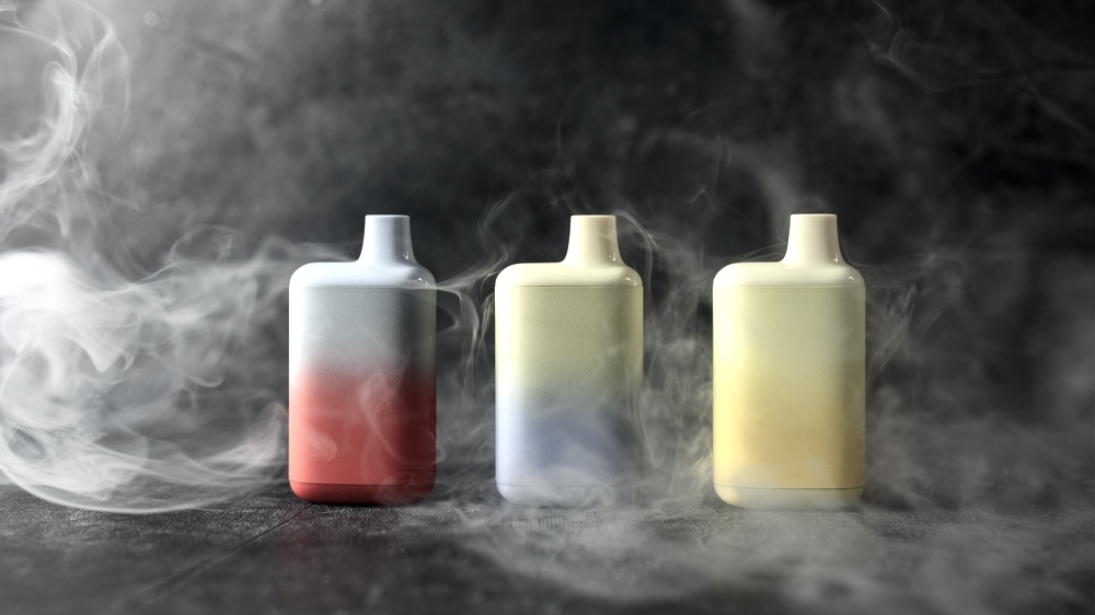 3 vaping device on a table surrounded by smoke 