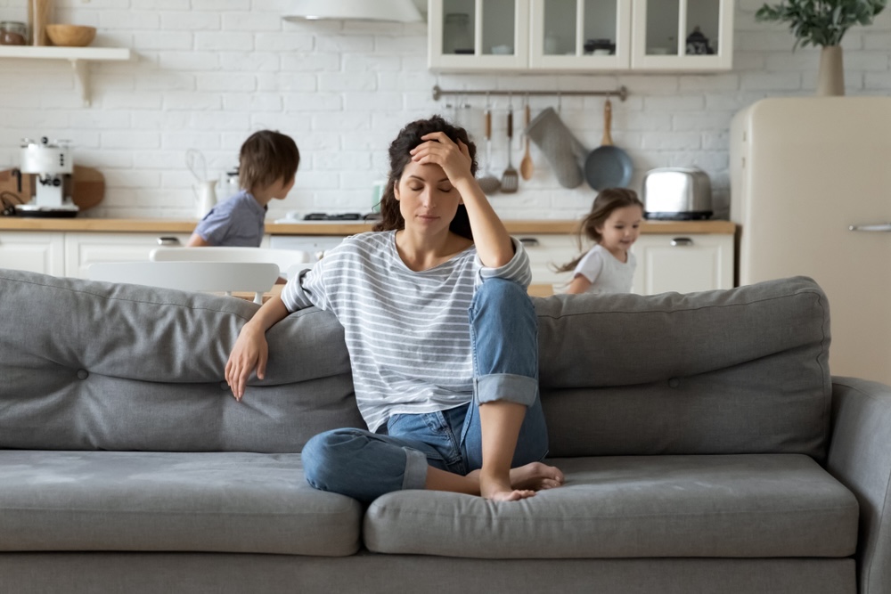 Mother on a couch facing too much stress from family life