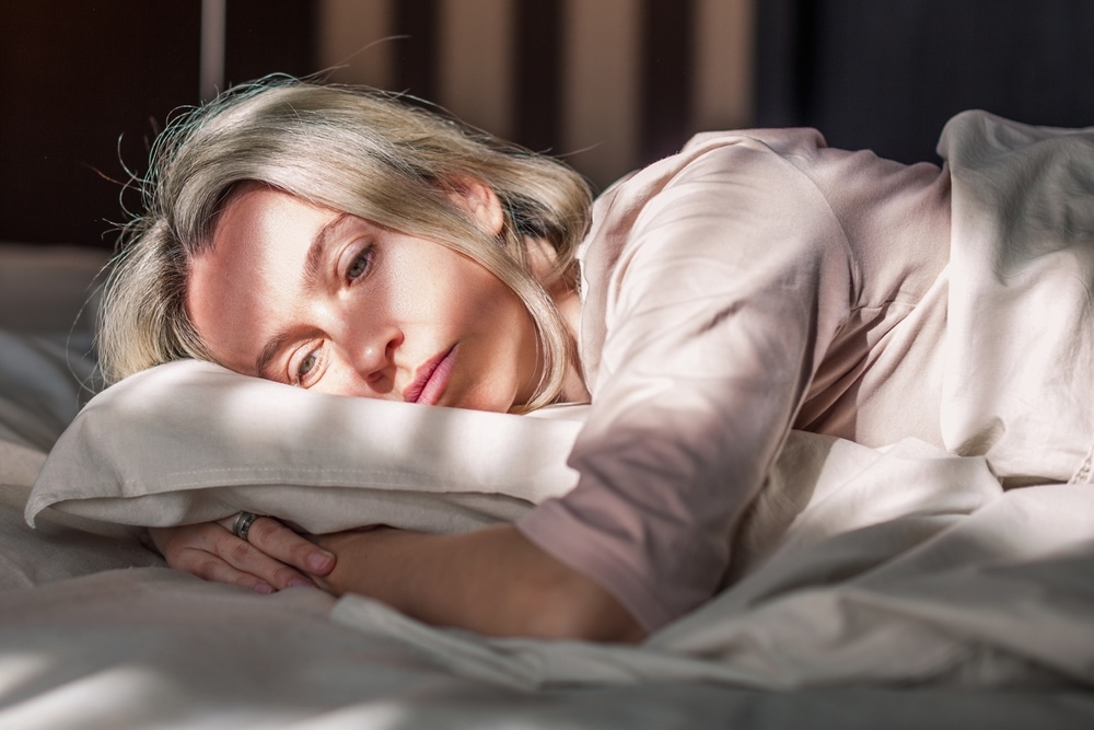 Elderly woman with white hair looking depressed because of her alcohol addiction relapse