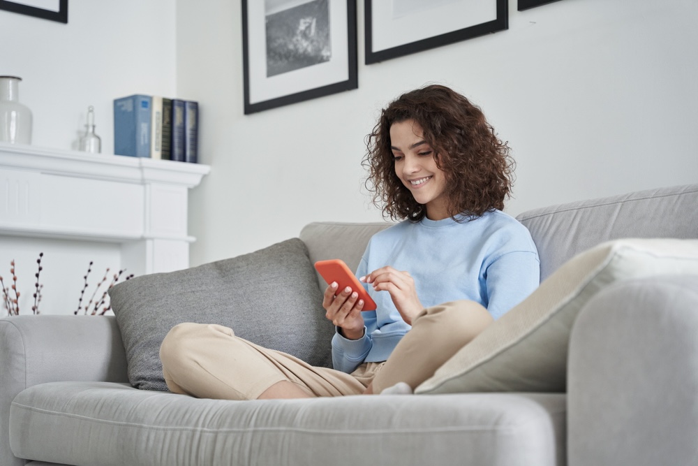 Woman holding a phone sending a congratulations on sobriety message