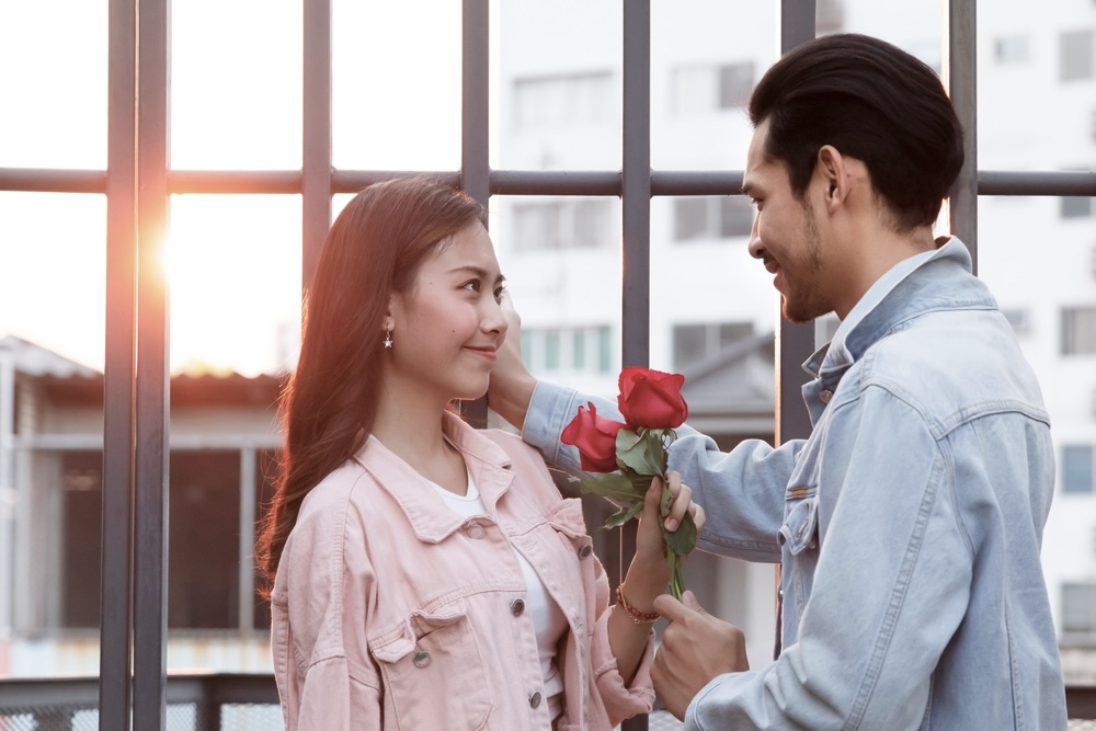 Couple in addiction recovery falling in love holding roses outdoors 