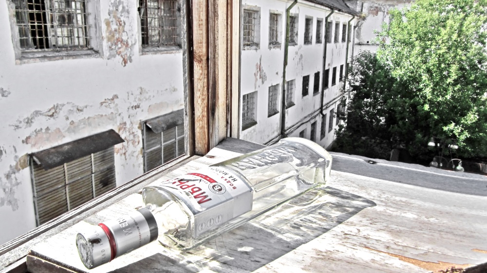 An old abandoned bottle of vodka on a steel roof