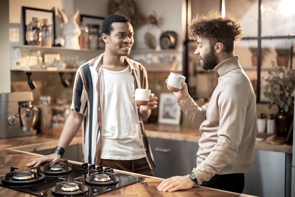 Two men talking in a kitchen of a sober home