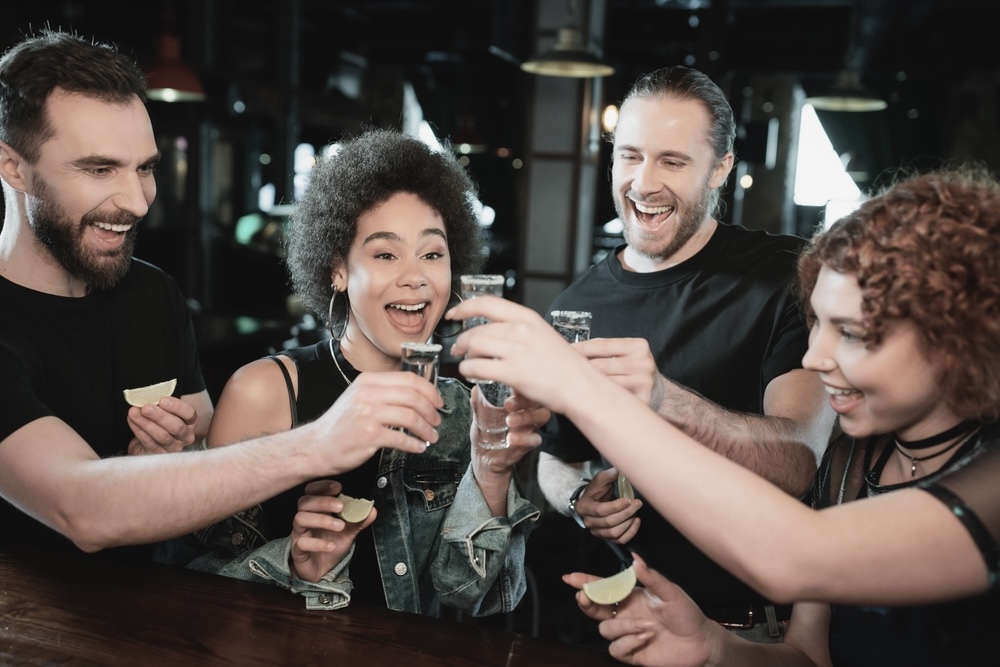 Drunk people enjoying tequila on a night out